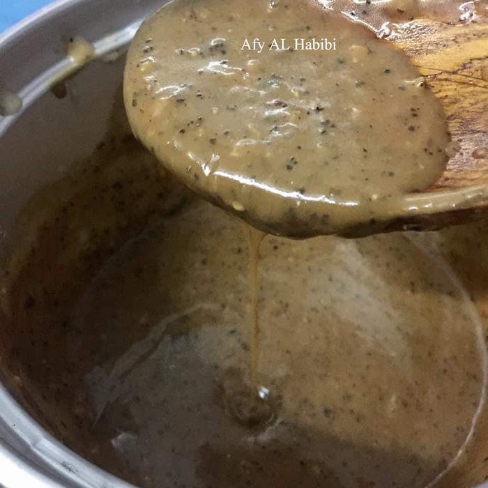 Semangkuk sos black pepper creamy berwarna perang gelap untuk dicicah dengan daging.
