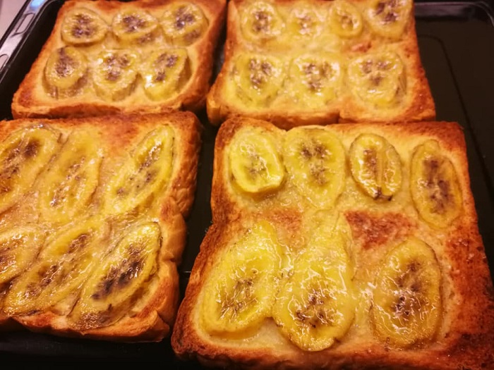 Sekeping roti pisang yang telah dibakar dengan taburan gula di atas pinggan.