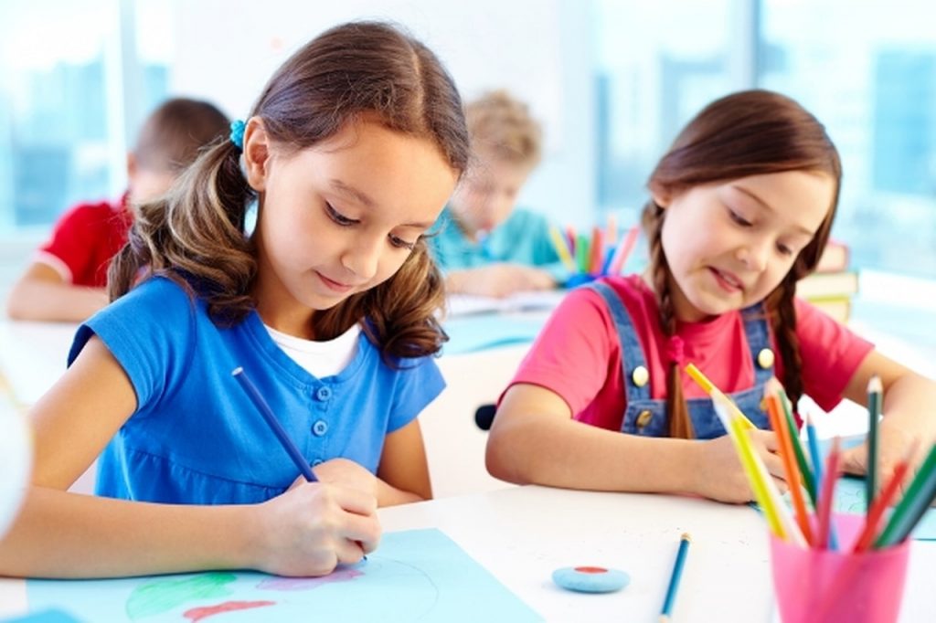 Murid sedang fokus menulis dan menyiapkan tugasan sekolah