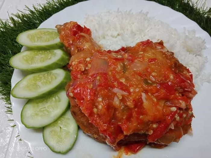 Sepinggan ayam goreng tepung dengan sambal geprek yang dipipis di atas lesung batu