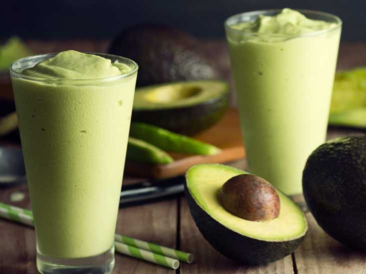 Buah avokado segar dipotong separuh menunjukkan biji di tengah