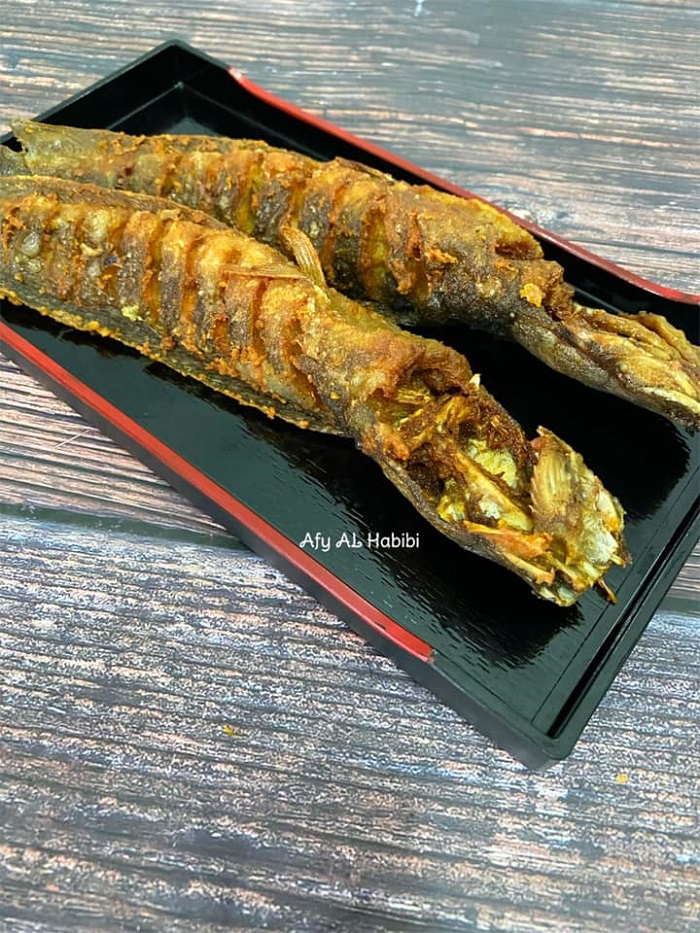 Ikan keli goreng yang rangup keemasan disusun di atas pinggan.