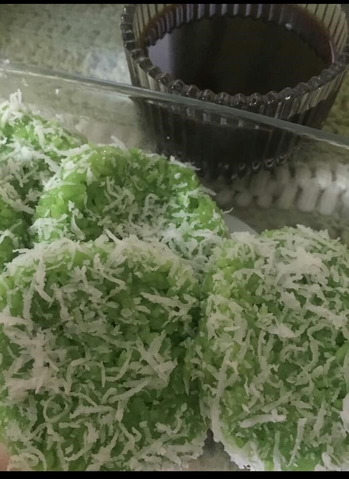 Gambar kuih lopes yang dipotong bulat berwarna hijau, ditabur kelapa parut dan diletak air gula Melaka.