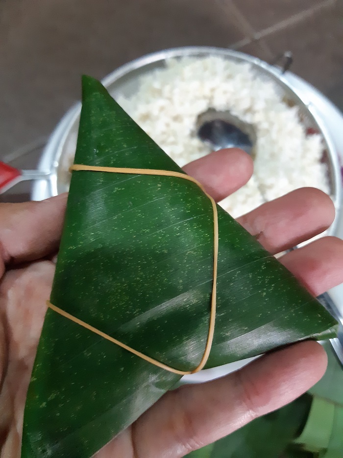 Daun pisang berisi adunan dilipat dan dititik
