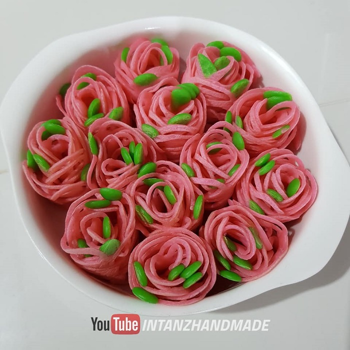 Roti jala dibentuk cantik menyerupai bunga ros berwarna-warni di atas pinggan.