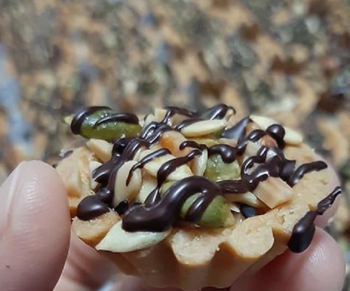 Tart Florentine berbentuk bulat dengan topping kekacang dan lorengan coklat cair di atasnya.