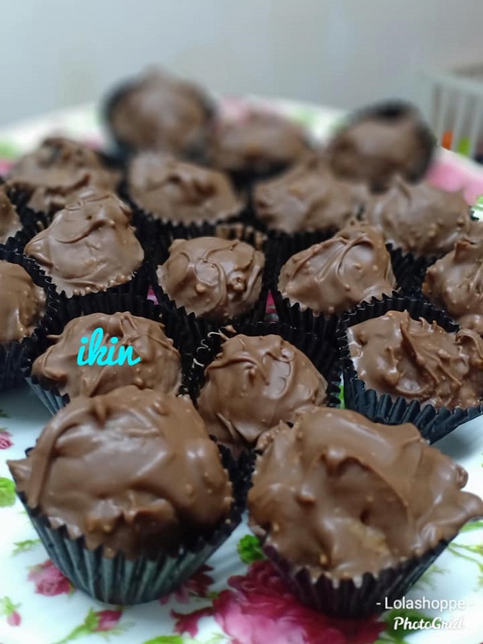 Gambar coklat eclairs tanpa bakar diletak dalam paper cup dengan taburan kacang.