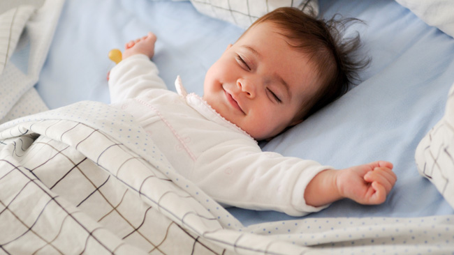 Gambar bayi sedang tidur nyenyak di atas katil