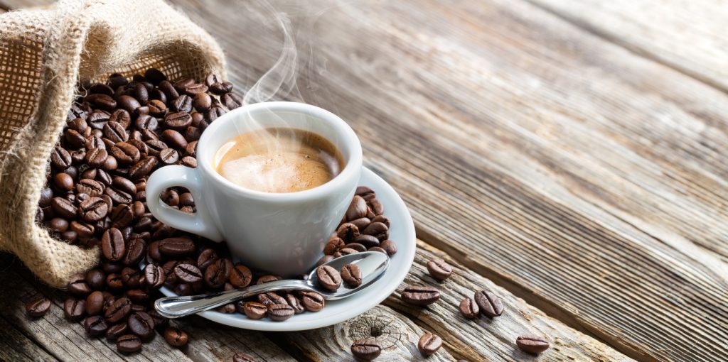 Cawan kopi dan biji kopi yang berbau wangi