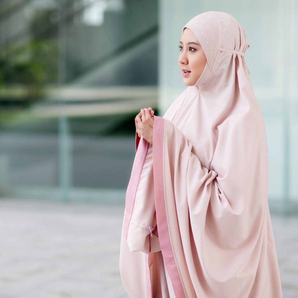 Gambar wanita muslimah berhijab menunjuk senyuman manis sebagai lambang isteri solehah