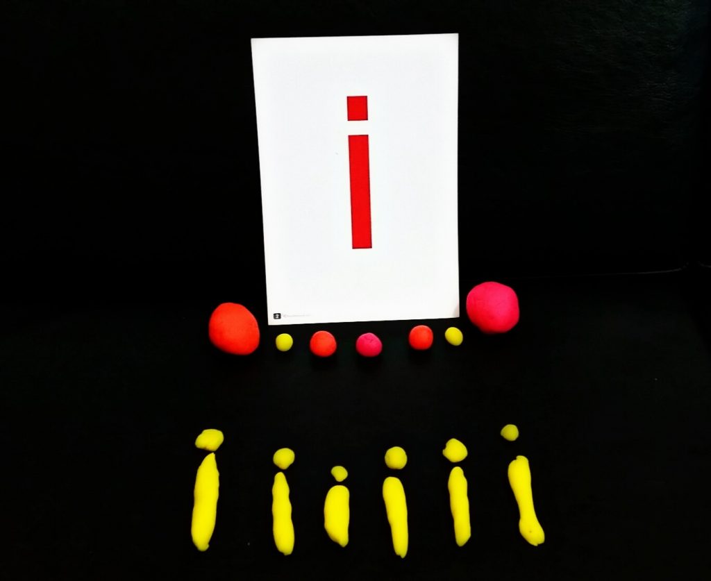 Kanak-kanak meniru menulis huruf di atas kertas