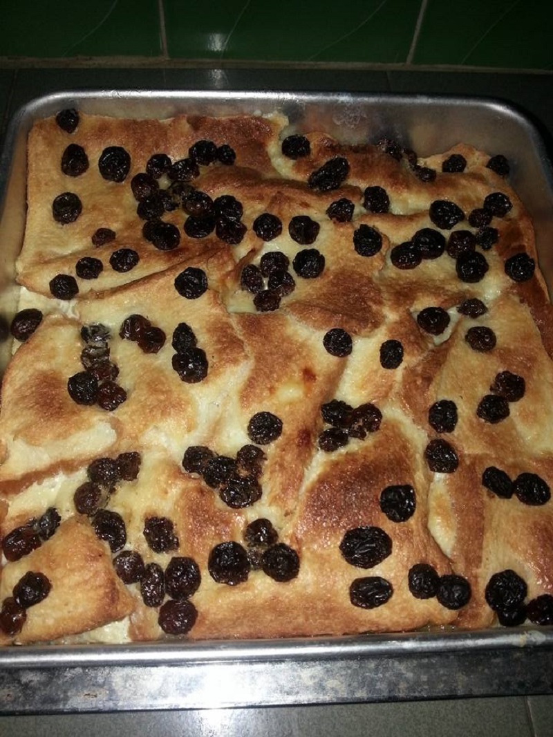 Gambar puding roti kastard yang telah siap dimasak dengan taburan kismis.