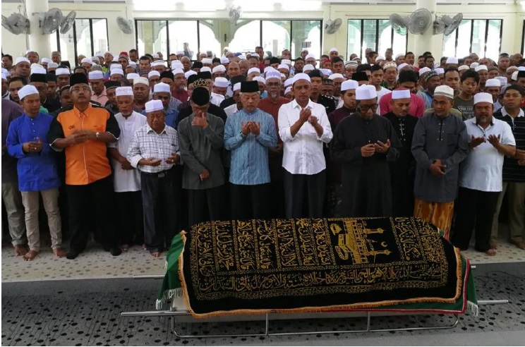 Jemaah lelaki sedang menunaikan solat jenazah di luar masjid