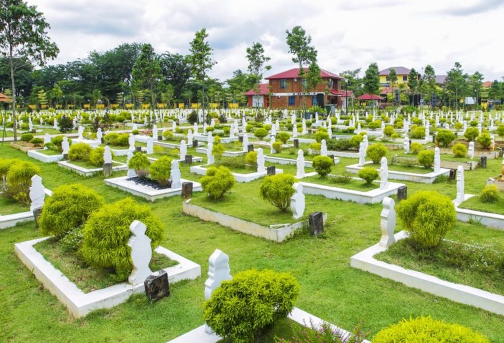 Seorang lelaki berdoa di kawasan tanah perkuburan