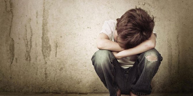 Gambar seorang anak lelaki duduk menyendiri berasa sedih kerana diabaikan