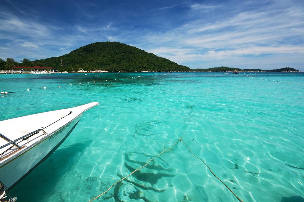 Pemandangan pantai berpasir putih dengan air laut jernih berwarna biru di Pulau Perhentian