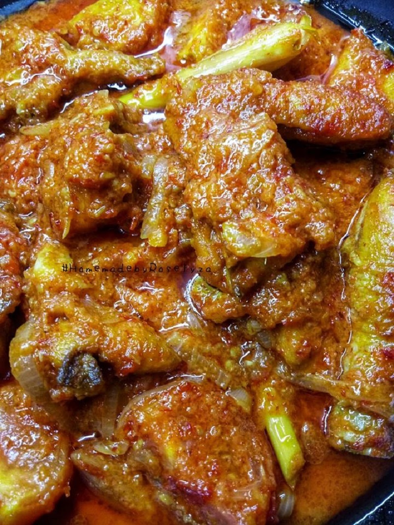 Hidangan ayam masak merah tradisional dengan kuah merah pekat dan hirisan tomato.