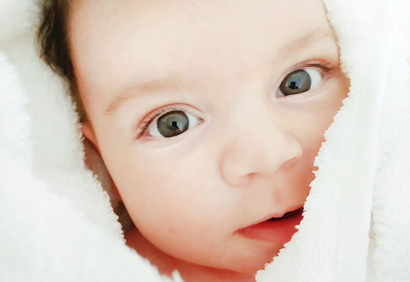 Ibu bapa menggendong bayi dengan hiasan daging aqiqah untuk majlis