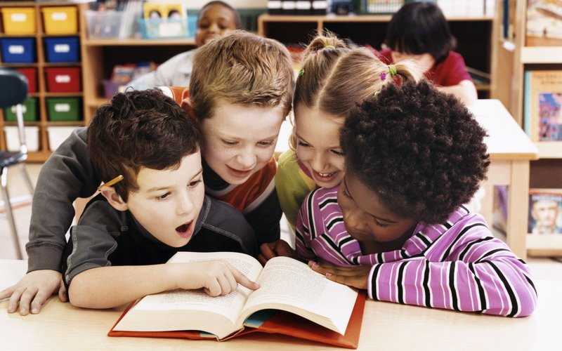 Ibu bapa membacakan buku cerita untuk anak kecil sebagai amalan mendorong minat membaca.
