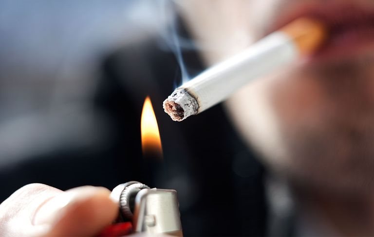 Ilustrasi sebatang rokok dengan asap dan tanda amaran bahaya kesihatan.