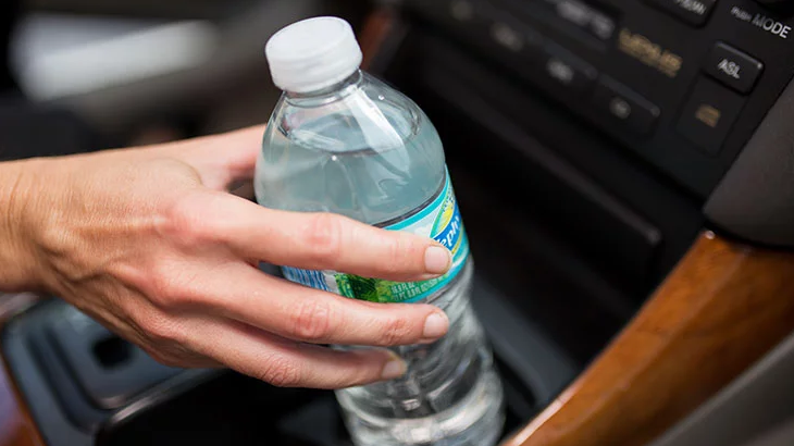 Ilustrasi pelbagai barangan bahaya seperti botol air dan powerbank di dalam kereta yang terdedah kepada haba.