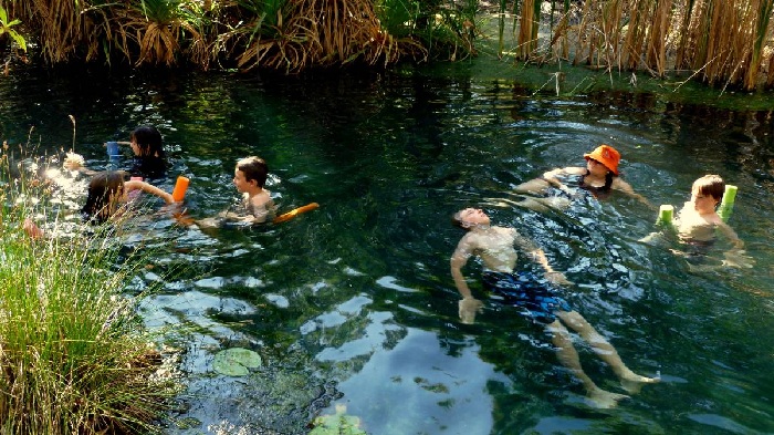 Keluarga sedang beriadah dan bermandi-manda di kolam renang.