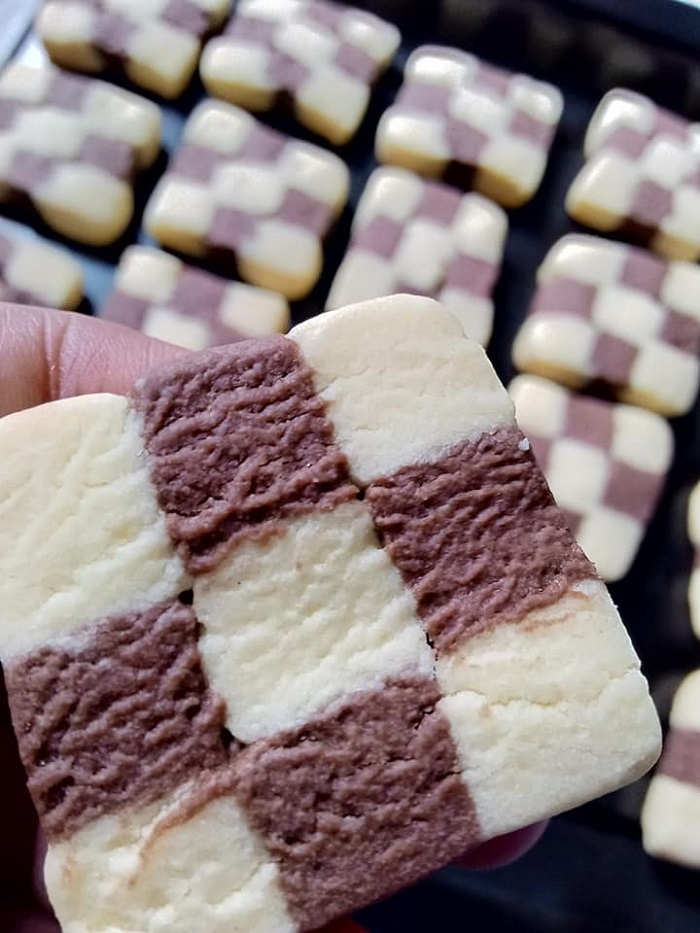 Gambar pelbagai bentuk dan warna biskut dam kotak-kotak ditempatkan di atas permukaan rata.