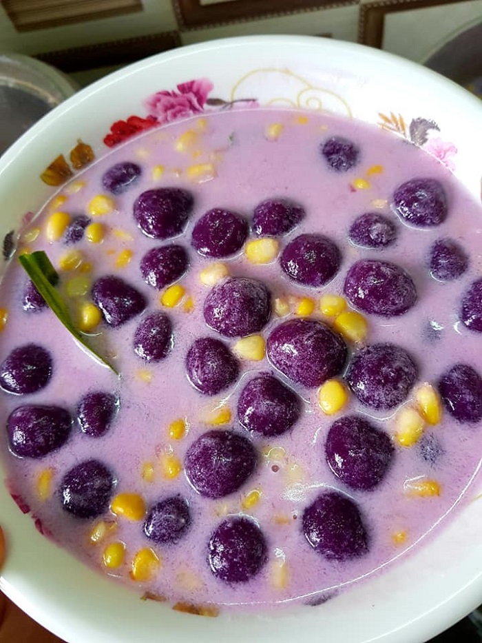 Sebuah mangkuk berisi bubur candil keledek ungu dengan kuah santan lemak manis.