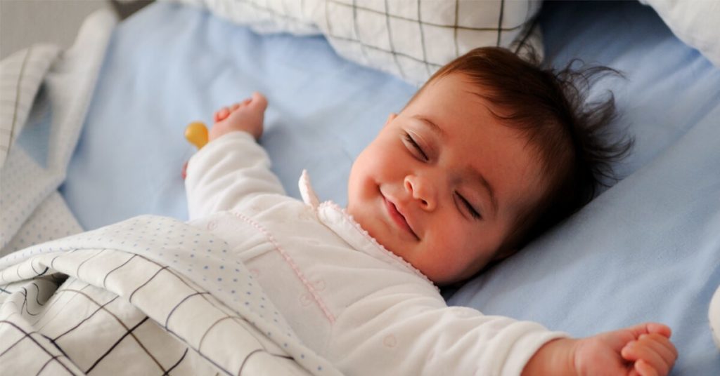 Gambar bayi sedang tidur dengan lena di atas katil