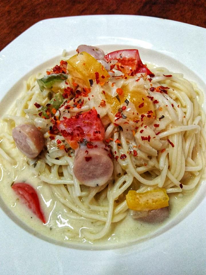 Sebuah hidangan spaghetti creamy carbonara pekat likat dengan daging cincang dan keju.