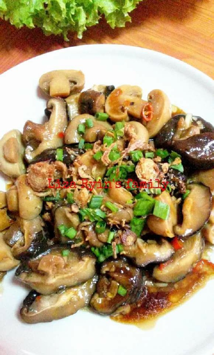 Cendawan shiitake sos tiram yang telah masak di atas pinggan dengan taburan daun bawang.