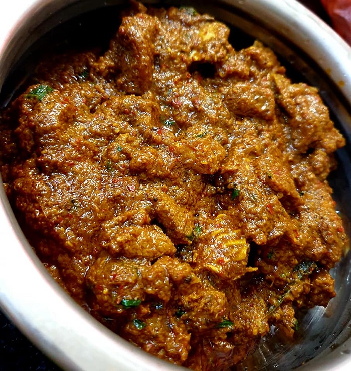 Sepinggan masakan Chettinad Mutton Masala berkuah pekat dengan daging kambing dan hiasan daun ketumbar.