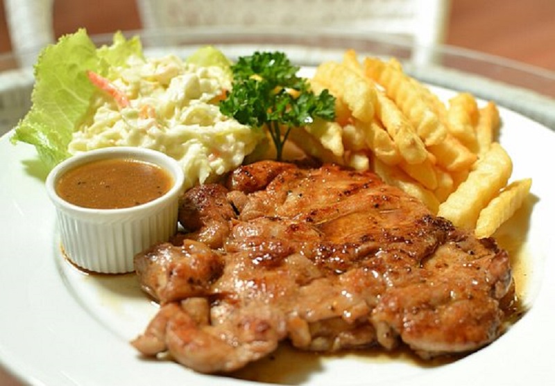 Hidangan chicken chop lengkap dengan ayam grill, sos lada hitam, kentang goreng dan coleslaw.