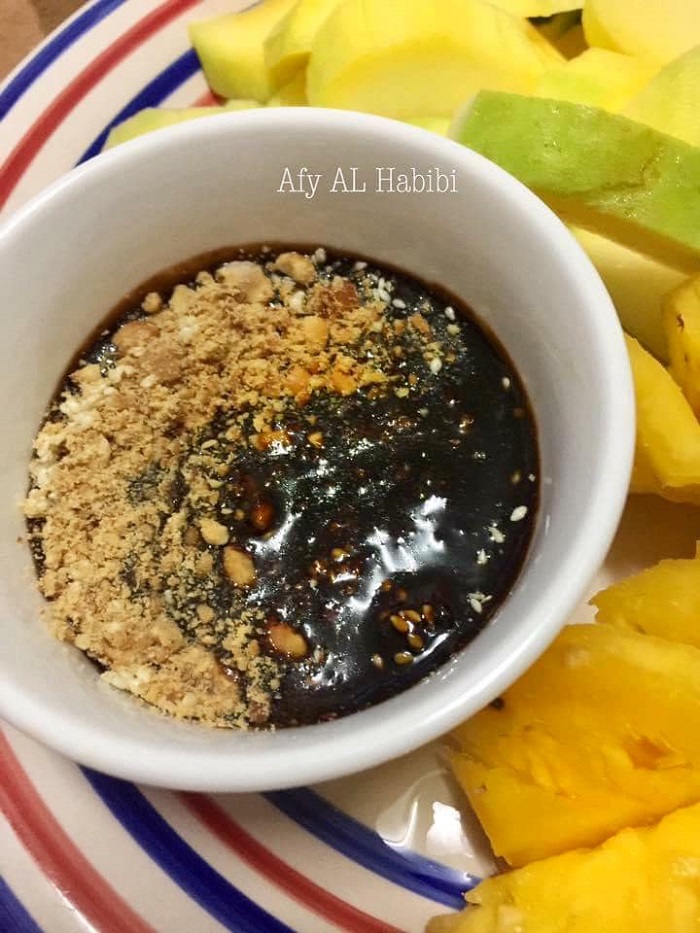 Mangga dan buah-buahan dipotong bersama kuah colek buah yang pekat bersama kacang tanah.
