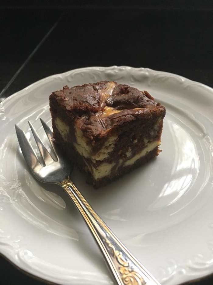 Kepingan cream cheese brownies coklat yang dipotong dan diletakkan di atas piring