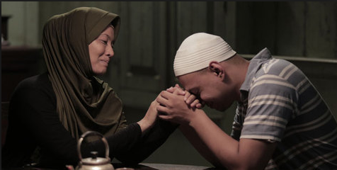 Gambar seorang anak sedang memeluk dan menyayangi ibu bapanya yang sudah lanjut usia.