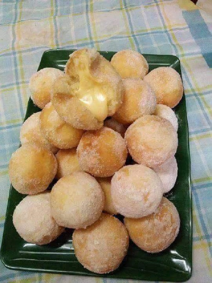 Donut yang telah digoreng dengan taburan gula aising dan inti cheese yang meleleh.