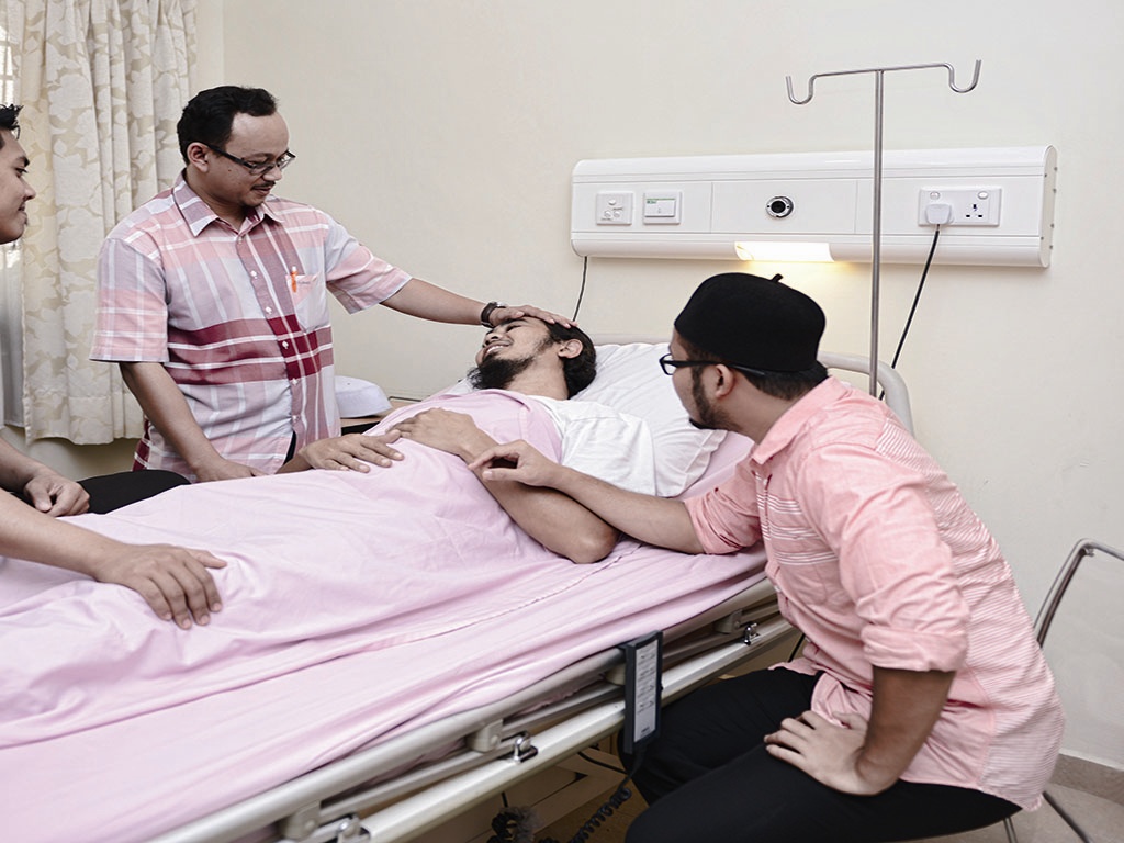Gambar orang menziarahi pesakit di wad hospital dengan membawa buah tangan.