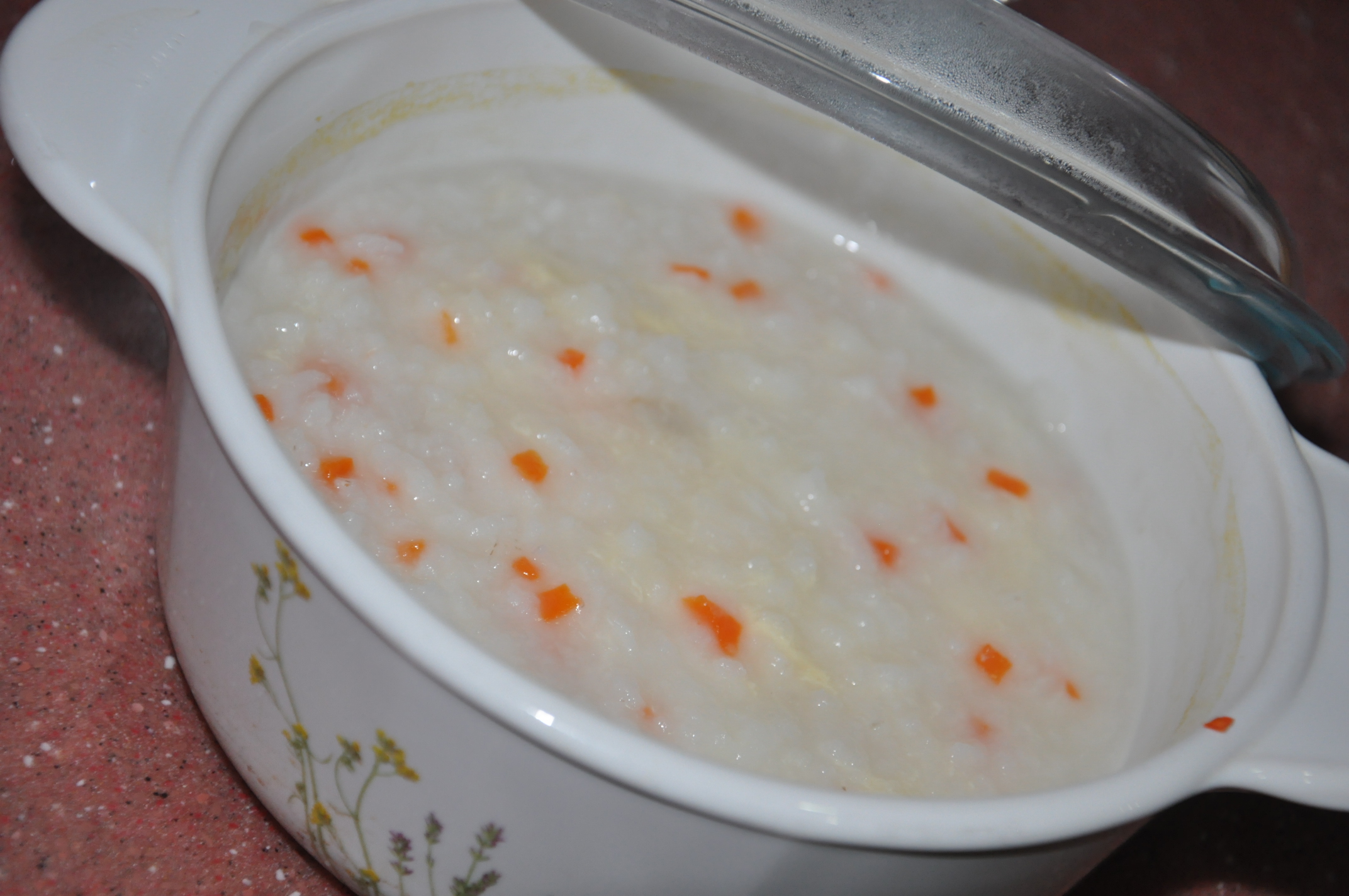 Pinggan bubur nasi bayi yang lembut disajikan bersama sudu