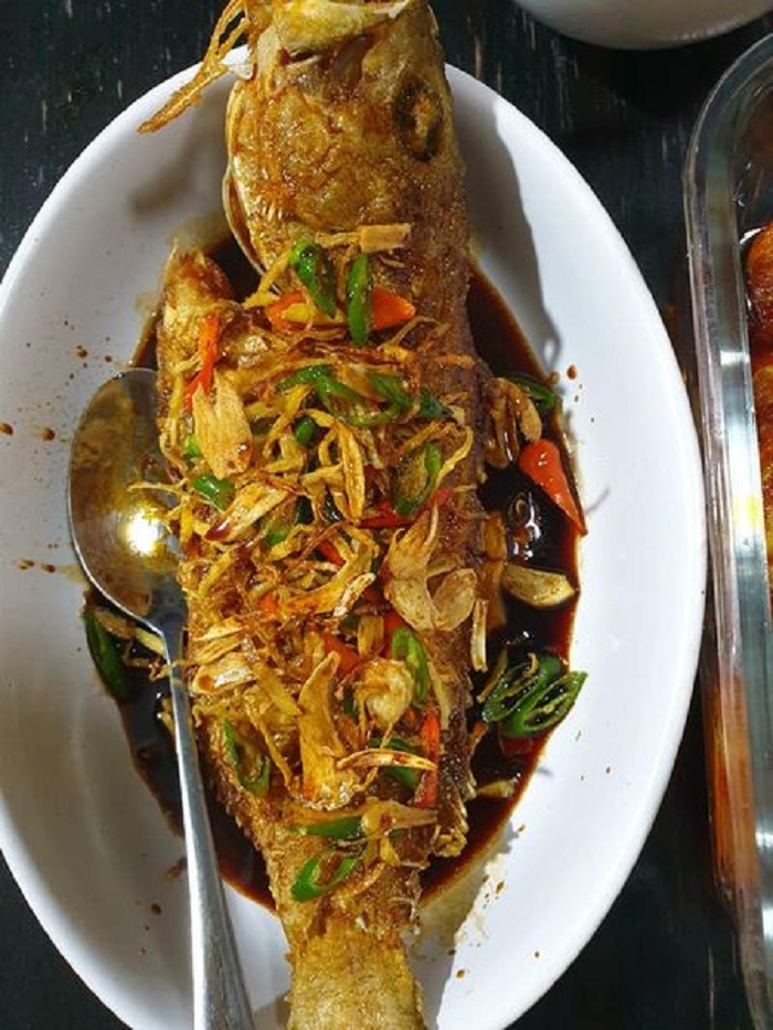 Pinggan hidangan ikan kerapu goreng celup tepung bersama kuah dan hirisan cili.