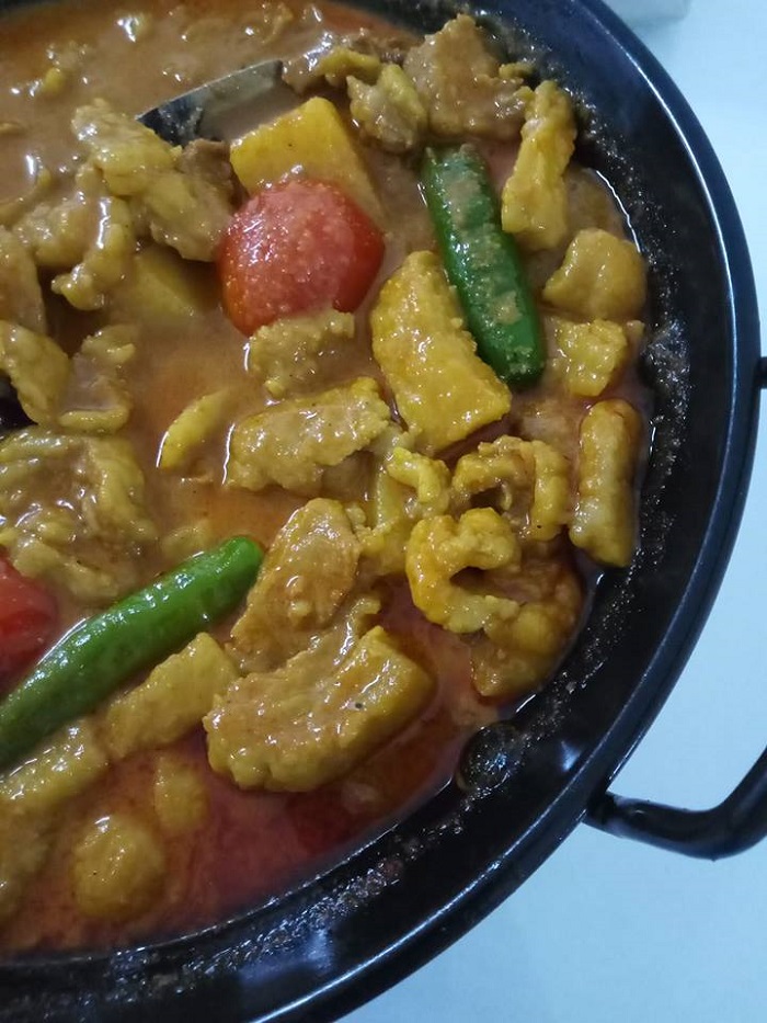 Sebuah mangkuk berisi gulai daging lemak dengan kuah pekat dan ubi kentang.