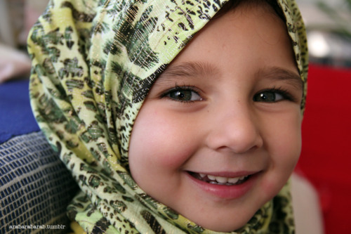 Ibu menyarungkan tudung kepada anak perempuan kecilnya sebagai tanda kasih sayang.