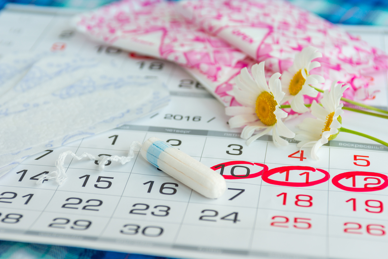Wanita memegang kalendar menunjukkan simbol period lambat