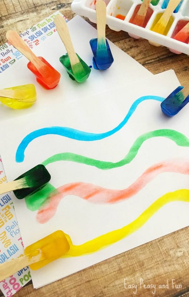 Anak kecil melukis menggunakan ais berwarna