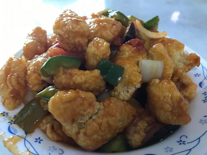 Hidangan ikan dori goreng bersalut sos masam manis dengan hirisan nenas dan lada benggala.