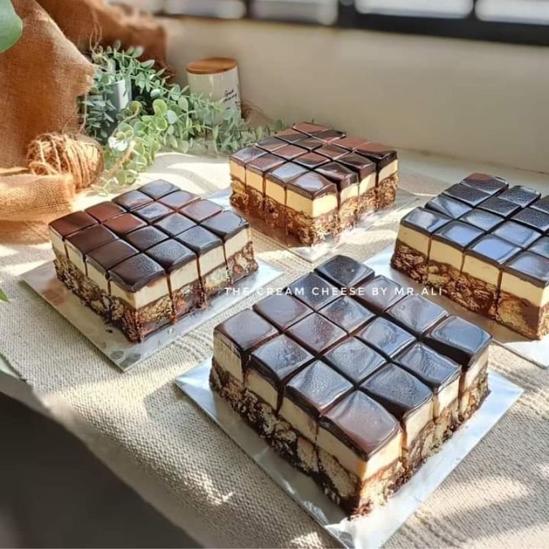 Potongan kek batik indulgence 3 lapisan dengan topping ganache dan cream cheese.