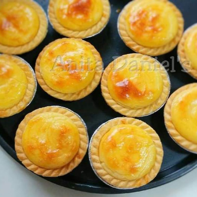 Foto Hokkaido cheese tart segar yang baru siap dibakar dengan filling keju yang lembut dan kerak berwarna keemasan.