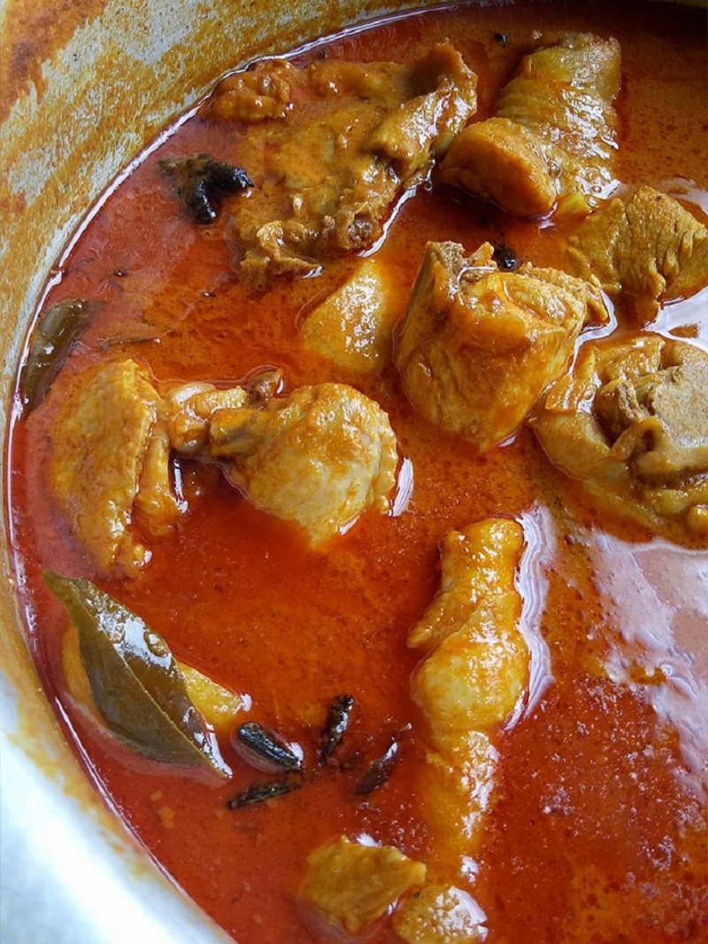 Hidangan kari ayam pekat dengan kuah berempah dan potongan kentang dalam mangkuk putih.