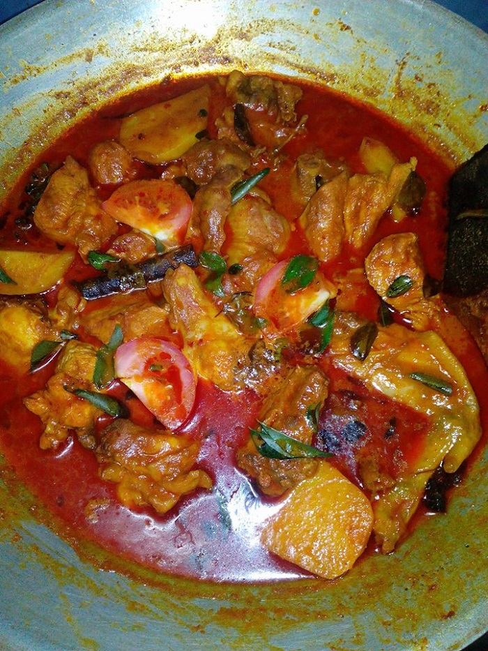 Sebuah pinggan mangkuk berisi kari ayam mamak dengan kuah pekat berempah yang dihidangkan bersama ubi kentang.