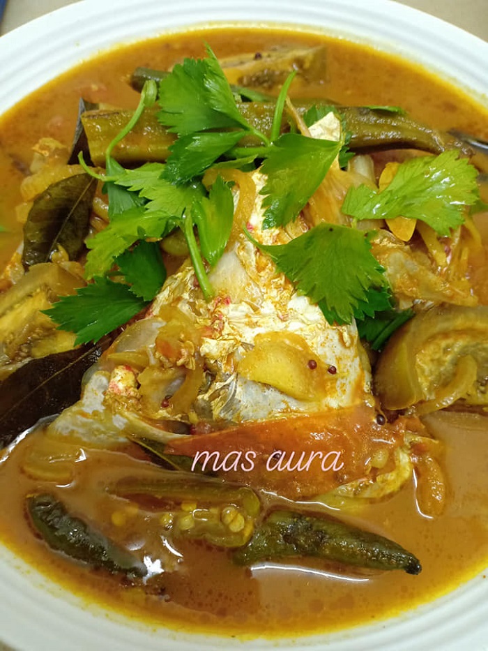 Sepiring kari kepala ikan merah dengan kuah pekat, bendi, tomato dan cili.